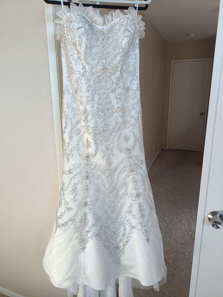 Oleg Cassini White bead embroidered wedding dress Size 10 Ivory mermaid style with a sweetheart neckline
Condition is used with a couple small tears