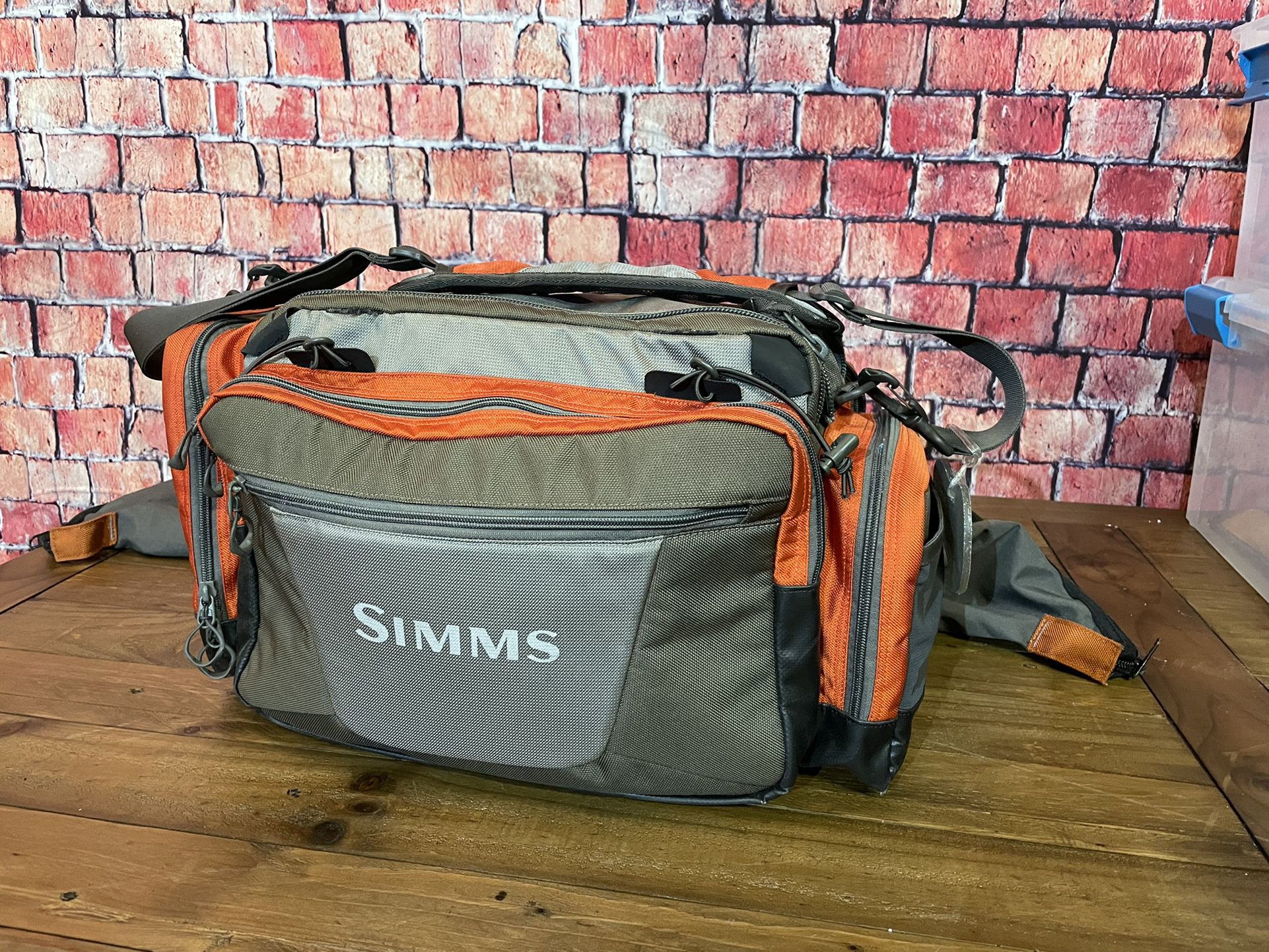 Simms fishing products Challenger Tackle Bag In Orange And Graystone 