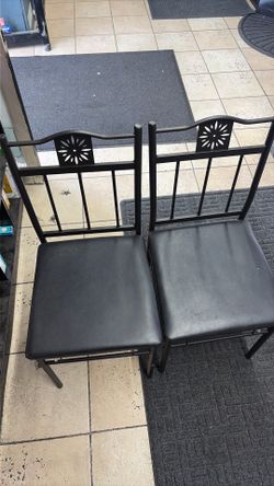 black metal dining chair features a distinctive floral-shaped cutout design in the backrest.