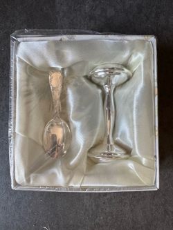 This is a vintage silver-plated Christening gift set featuring a designed spoon and a matching egg cup.