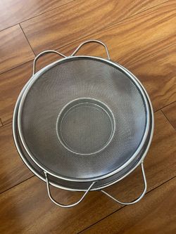 Nesting set of stainless steel fine-mesh colanders with looped side handles.