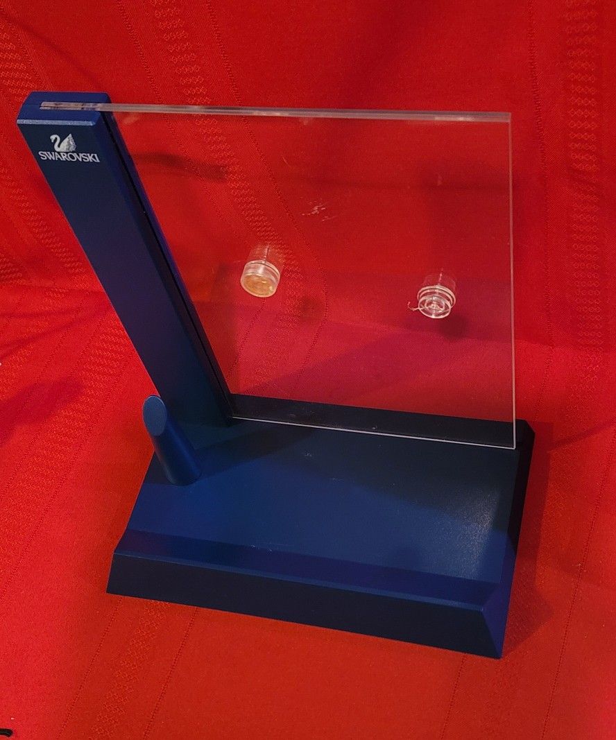 Blue and clear acrylic display stand featuring the Swarovski logo. Can Hold An 8x10