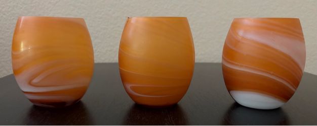 Set of 3 Pier 1 Imports frosted art glass votive candle holders in amber/orange swirl pattern.
