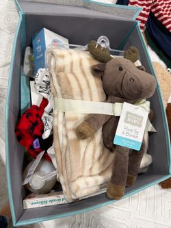 Assorted brand new baby items - clothes, booties, pacifiers and more