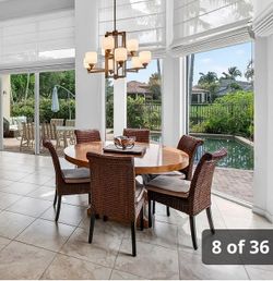 Brown wood round table with matching rattan chairs