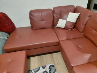 Red faux leather sectional and ottoman