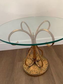 A mid-century Hollywood Regency gilded side table with glass top.