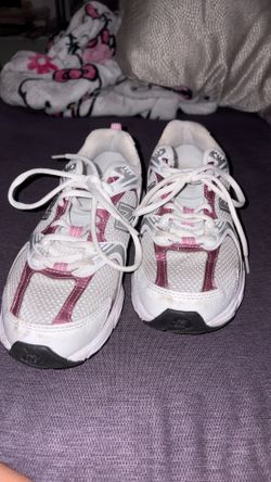 These white and pink New Balance 530 sneakers feature a retro-inspired design with mesh paneling.