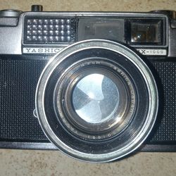 VintGe Yashika Lynx 1000 Camera With F=4 5 Cm Lems. Flash Lens And A Piece Of Metal Behind It Is Loose .  Untested
