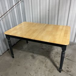 Farmhouse-style dining table with a natural Pine top and green painted legs with drop leaf