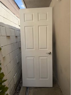 White 6 panel interior door with door handle.