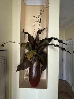 Vase with elephant ears plant leaves