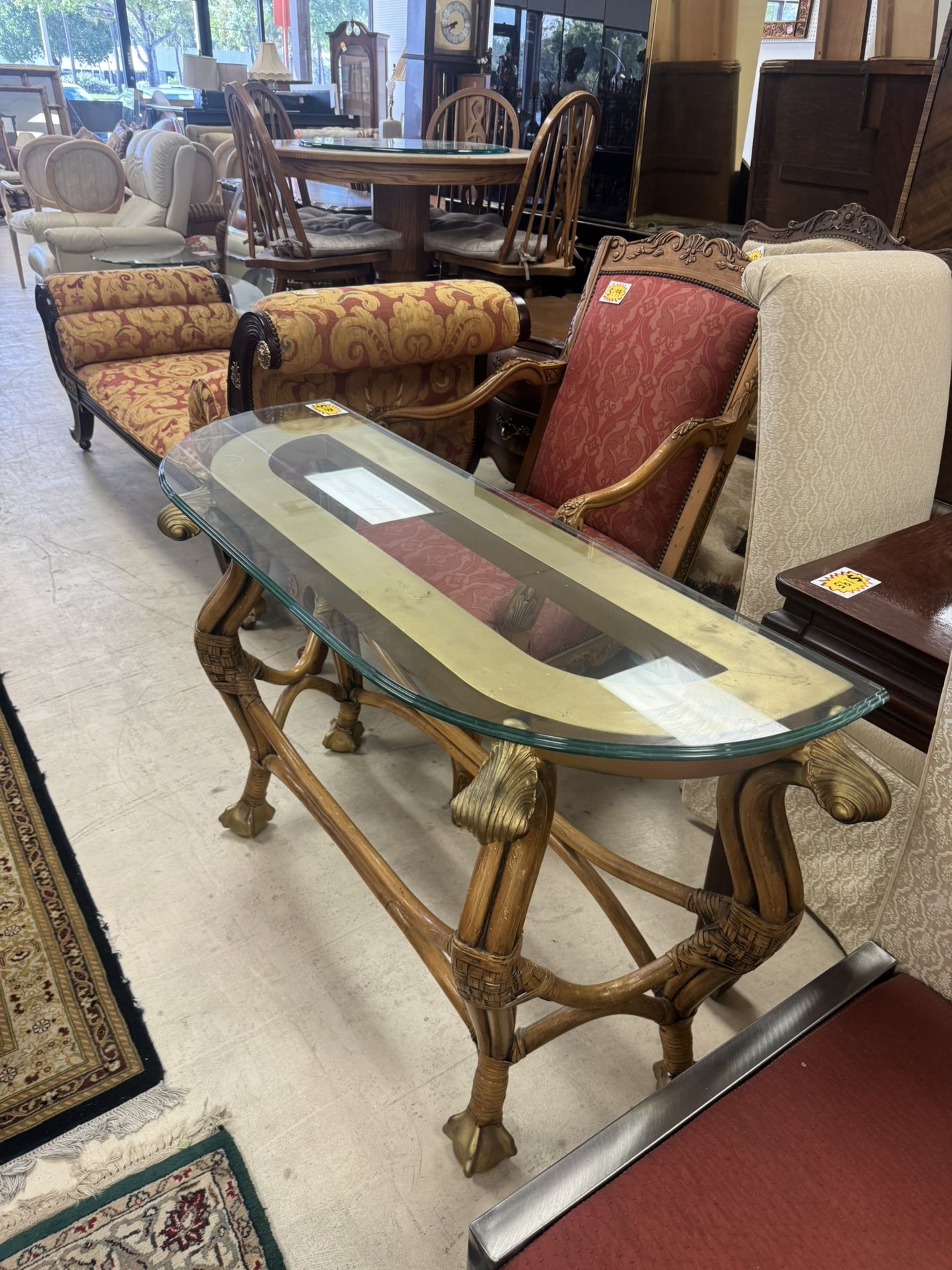 glass-top console table with a bamboo or rattan base and ornate gold-colored accents - 47”x 17”