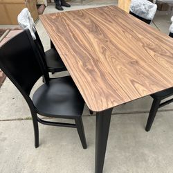 Brand New. Mid Century Modern walnut Dining Table With 4 chairs. Set retails over $1200