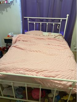 Full size white metal bed frame and mattress with bedding