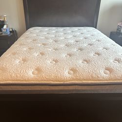 Solid wood bedframe with mattress.  Dark brown.