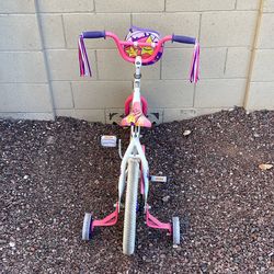 Little girl, bike with training wheels