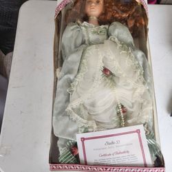 Centennial Collection" porcelain doll featuring curly red hair and a green Victorian-style dress. 