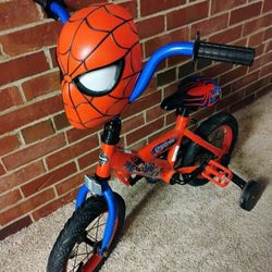 SPIDER MAN BIKE WITH TRAINING WHEELS  & THE HEAD LIGHTS UP  & STORAGE IN BACK OF HEAD/ REASONABLE OFFERS WELCOME