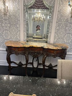 Carved wood console table with a marble top