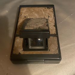 The image shows a vintage Polaroid SX-70 camera. This camera is a single-lens reflex (SLR) instant film camera known for its folding design. 