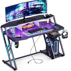 MOTPK Gaming Desk with Power Outlet & LED Lights, Gaming Computer Desk 47inch with PC Storage Shelf, Gaming Table with Carbon Fiber Texture, Gamer Des