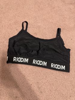 Black sports bralette with RIDDIM elastic band. Lightweight, stretchy fabric for gentle support. Thin adjustable straps for a custom fit. Simple silh