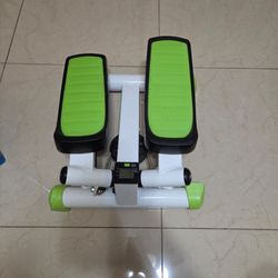 Compact twist stepper equipped with an LCD monitor and green foot pedals.