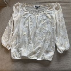 white and gold metallic blouse featuring lace detailing on the neckline
