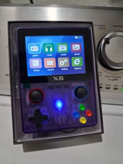 X6 Handheld retro video game console in transparent purple.  New.   fully laminated IPS OCA screen.  Features a dual 3D rocker design 4- core 32 bit p