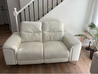 Modern Beige Leather Reclining loveseat , it features reclining functionality.