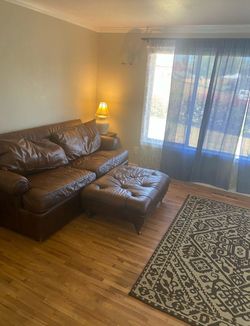 Two leather sofas with matching ottoman