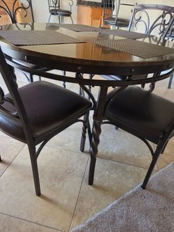 Dinner table with 4 leather seated chairs.
