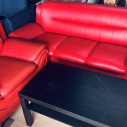a red leather sofa set (1 large + 1 small) with a black coffee table.