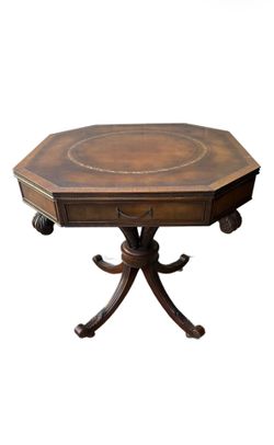 Antique English Regency-style drum table is constructed from mahogany wood and features an octagonal leather top with gold tooling