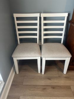 3 white chairs with cushions