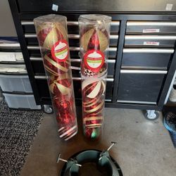 Two sets of red and gold ornaments and a green tree stand.