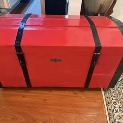 Red Storage Trunk with Wheels  Very sturdy solid wood red storage trunk with black metal hardware. Solidly built and heavy, with wheels on the bottom