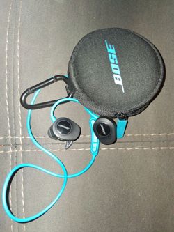 pair of BOSE SoundSport Wireless Headphones alongside their circular black carrying case.