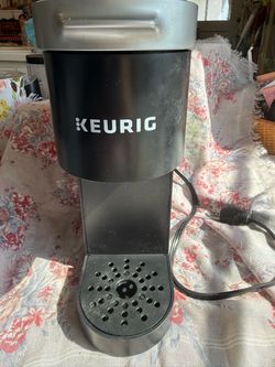 Black and silver Keurig single-serve coffee maker with drip tray and power cord. TESTED WORKS