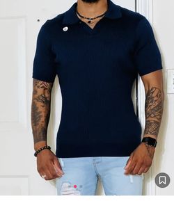 A cable knit polo shirt featuring an allover textured construction, basic collar