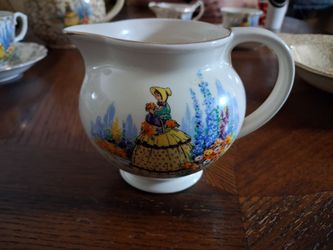 vintage Falcon Ware cream jug decorated with a transfer design of a "Crinoline Lady" in a flower garden.