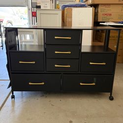 This product is a modern 7-drawer fabric dresser featuring a sturdy steel frame, a durable MDF wood top, and a side storage pocke