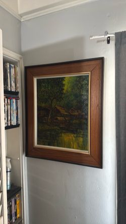 This framed vintage impressionist oil painting features a Southeast Asian or tropical river village scene with traditional thatched-roof stilt houses 