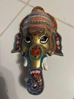 ornate metallic Ganesha wall hanging face decorated with colorful enamel work, beads, and faux gemstones