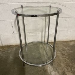 Glass and Chrome Side Table  Round glass side table with chrome frame.  Good pre-owned condition.   Measurements:  18” Round x 24” Tall  Pick up avail