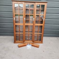3 door Media storage cabinet Walnut color wood & glass 47"W X 61.5"T X 9.5"D with 18 adjustable shelves expandable to 24