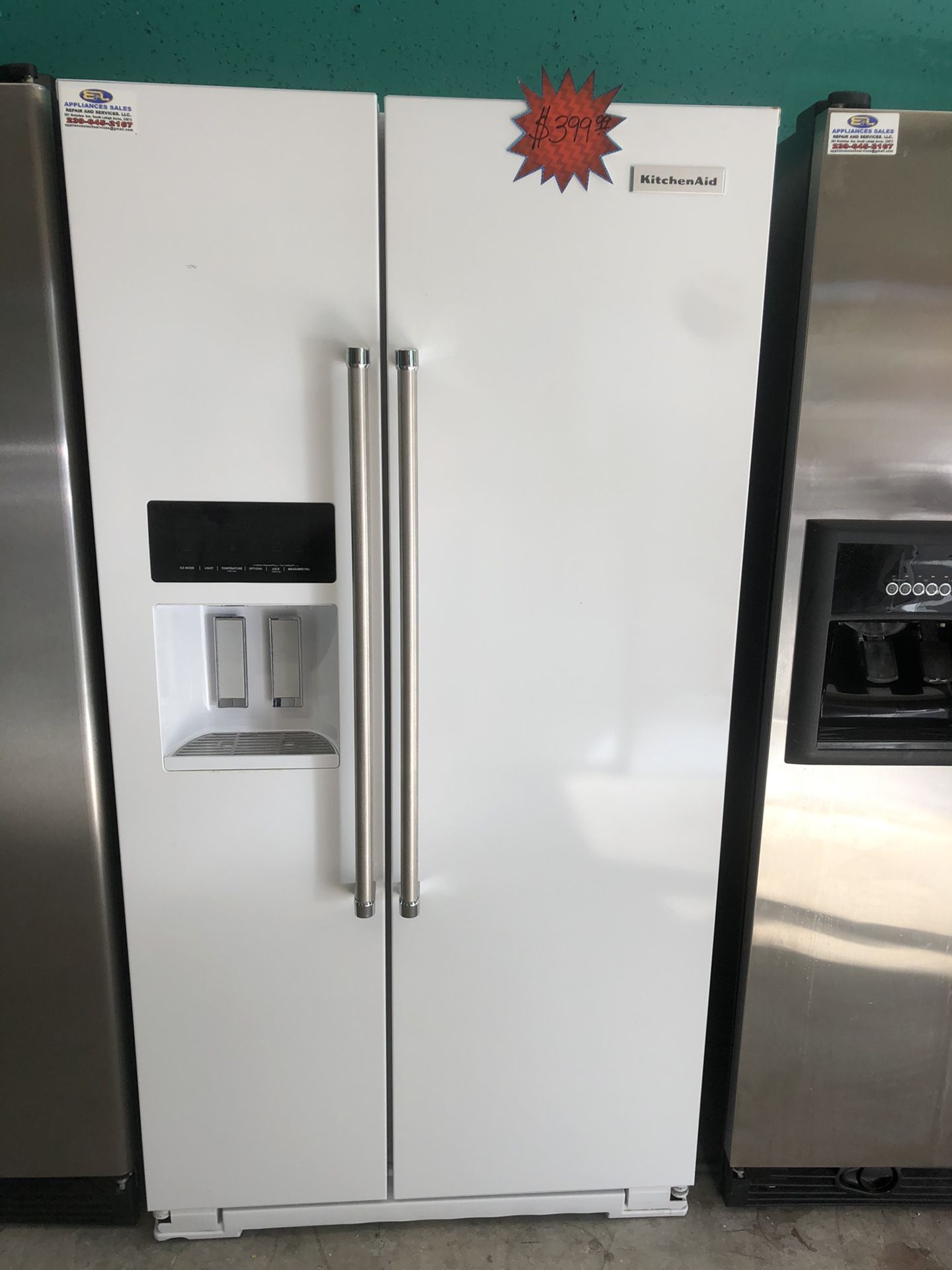 A white Kitchen Aide side by side refrigerator