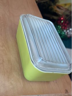 Vintage Pyrex refrigerator dish in a green or yellow color, often associated with the Verde or Avocado lines