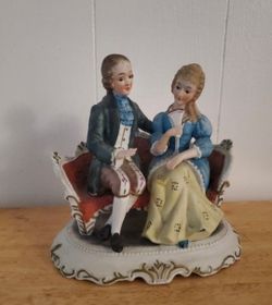 Vintage couple sitting in couch figurine decor
